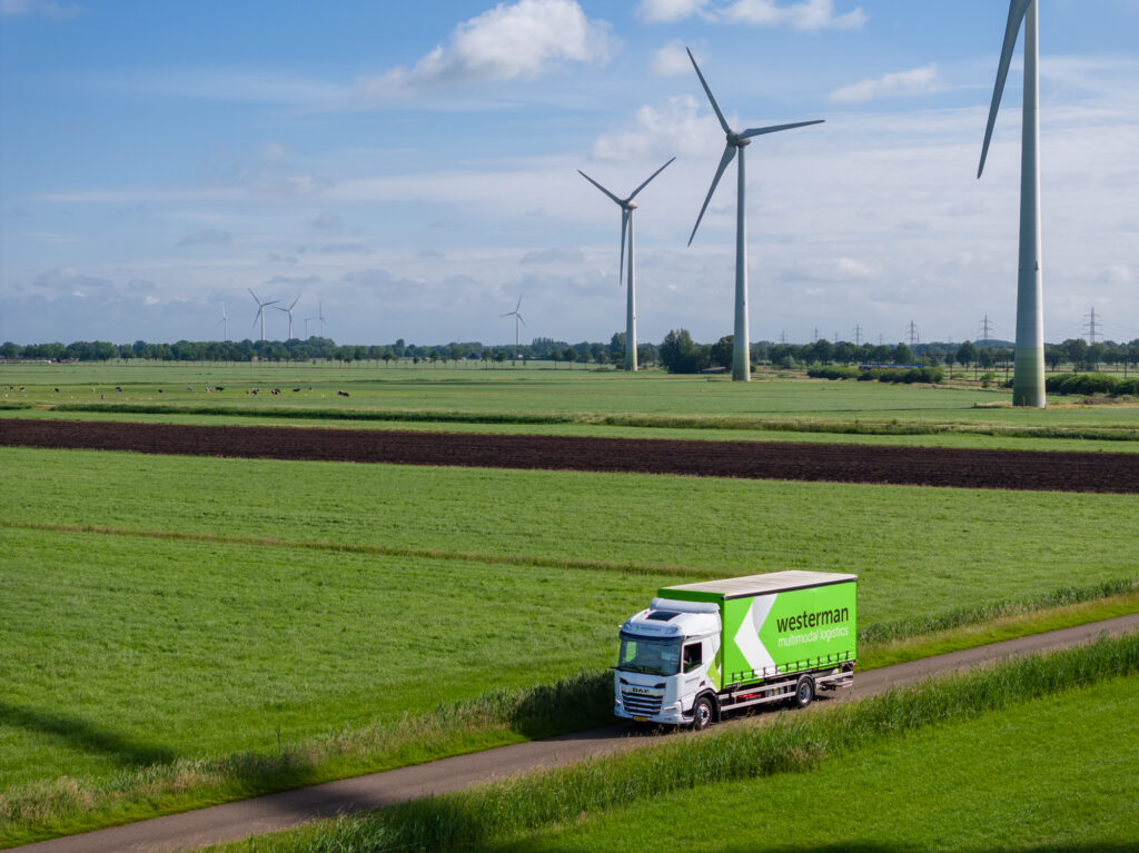 Truck van Westerman op weg naast windmolens