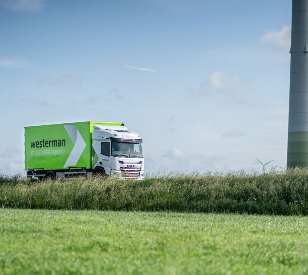 Westerman-truck in weiland met windmolens