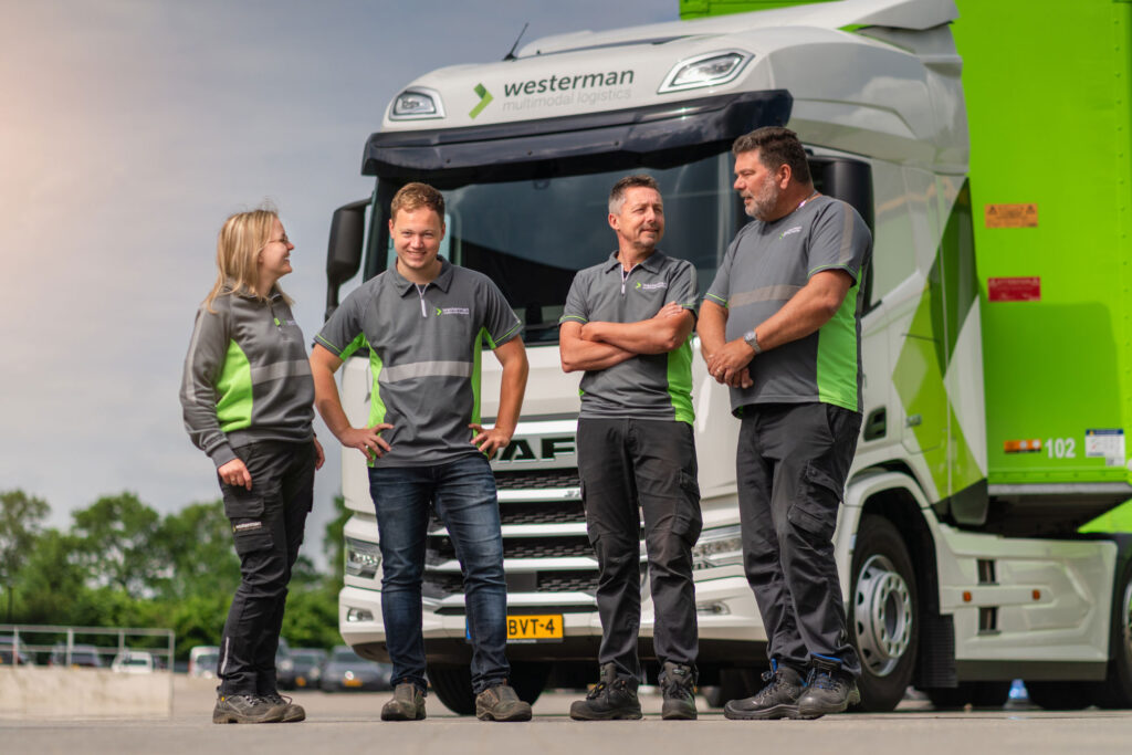 Teamfoto medewerkers in werkkleding voor vrachtwagen