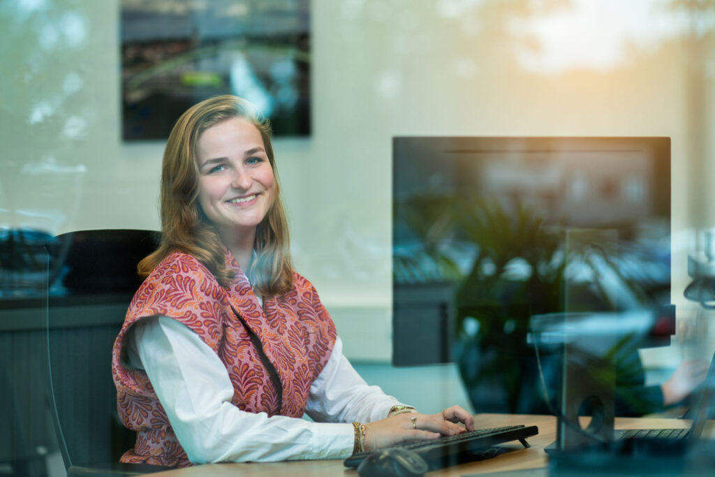 Vrouw achter laptop met glimlach