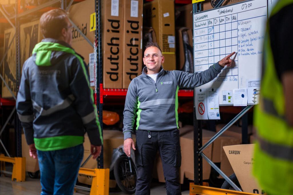 Logistiek medewerker wijst naar planbord