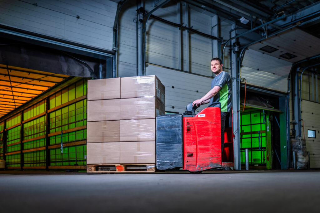 Logistiek medewerker laadt pallet met palletwagen in trailer